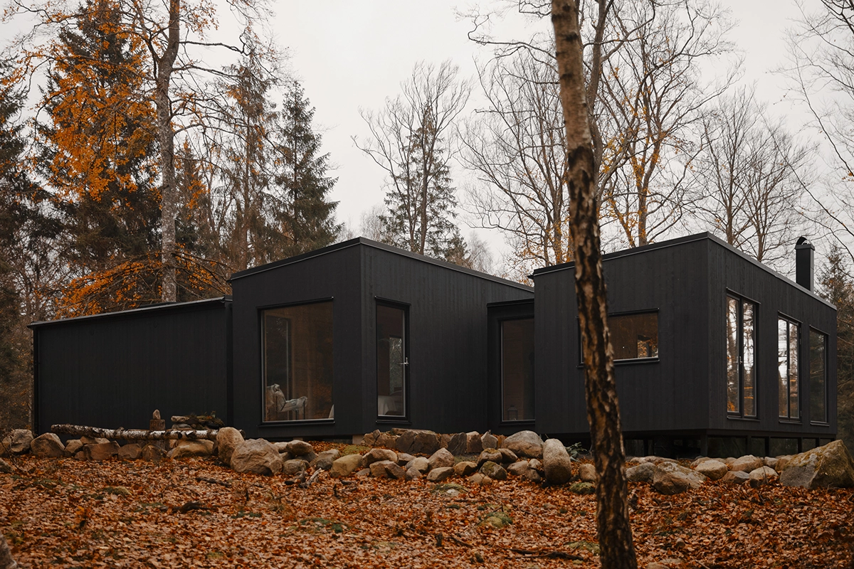 Modulhus e-länk, svart hus på tomt i naturen