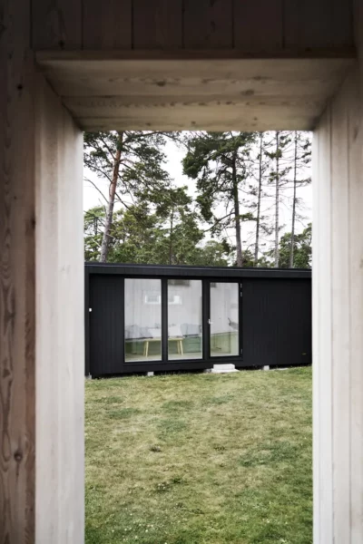Bygga gäststuga attefallshus med svart panel och tre stora fönster